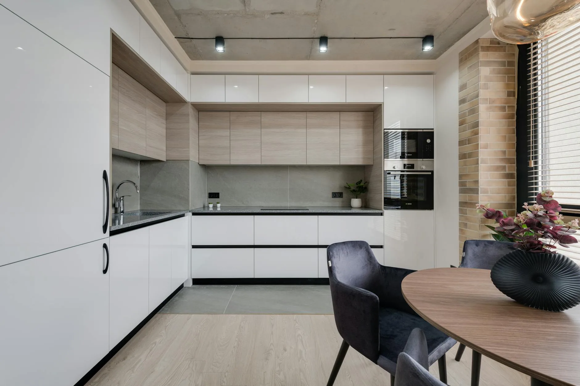 modern editorial kitchen idea: Two-Tone Cabinetry with cream and warm neutrals with sage green and terracotta accents, designer-curated modern kitchen